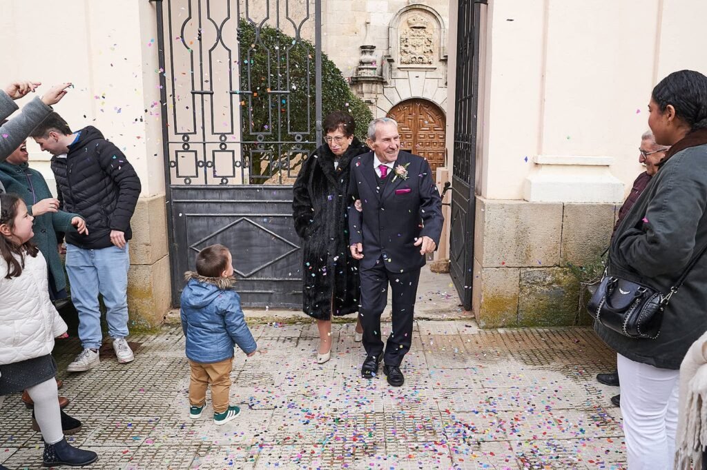 Personas lanzando arroz a una pareja de recién casados en una iglesia