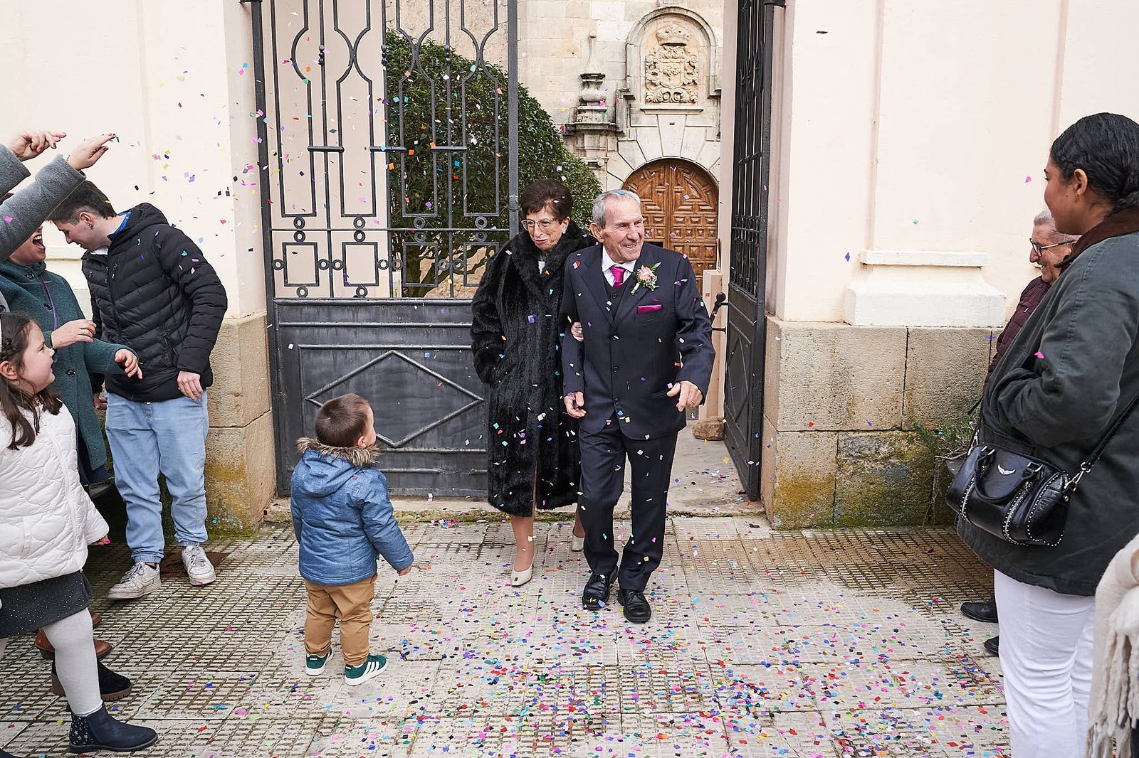 Personas lanzando arroz a una pareja de recién casados en una iglesia