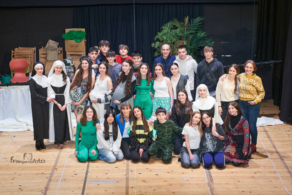 Grupo de jóvenes encima de un escenario tras actuar