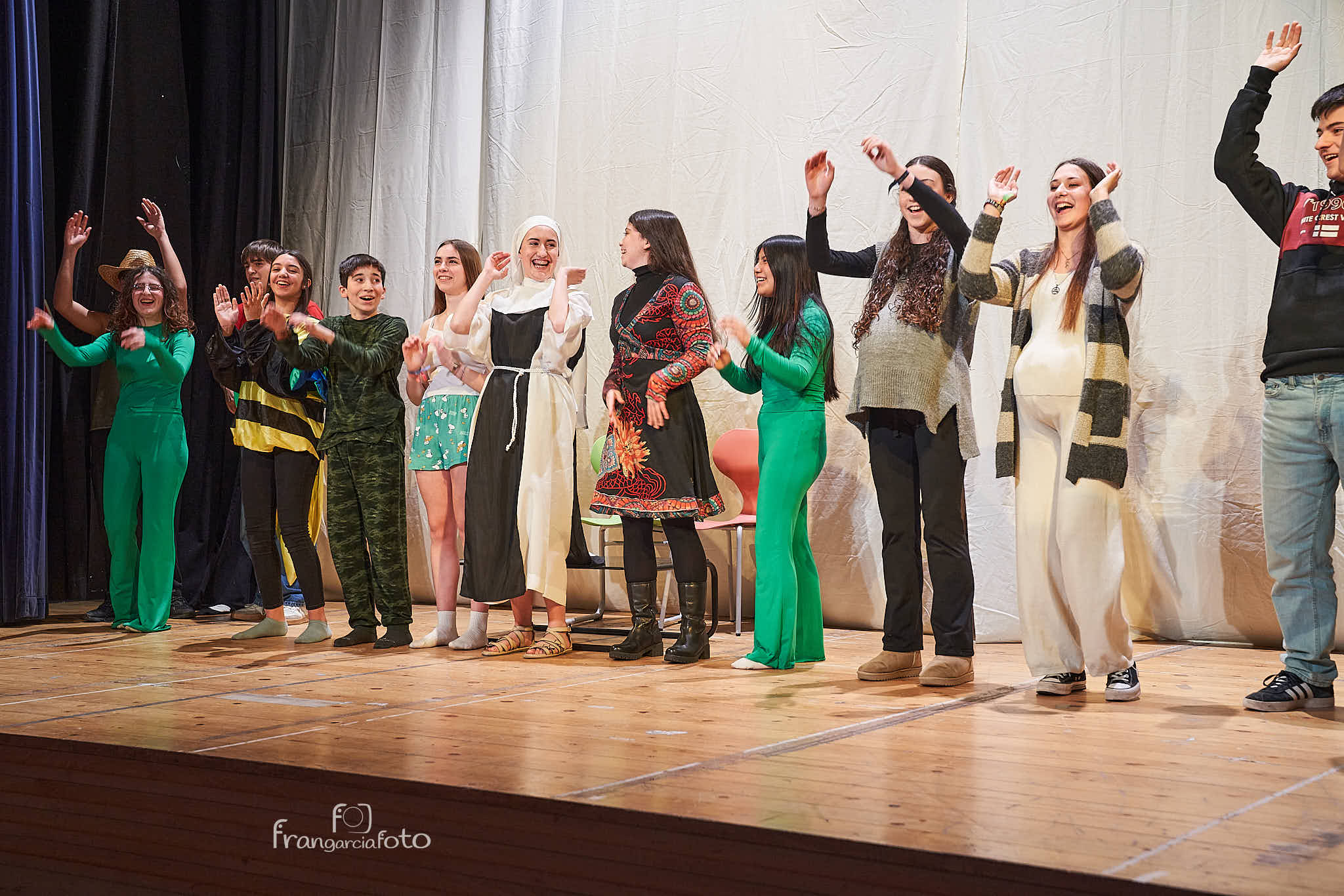 Grupo de jóvenes encima de un escenario tras actuar