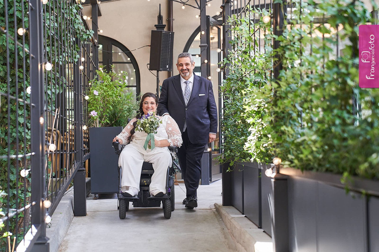 Pareja de novios posando en un jardín interior de un Hotel