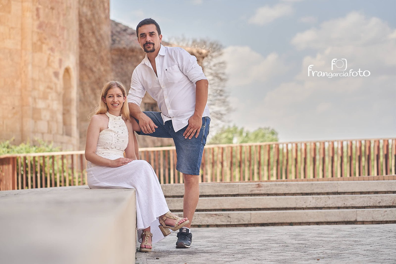 Pareja de novios posando sentados en una plaza