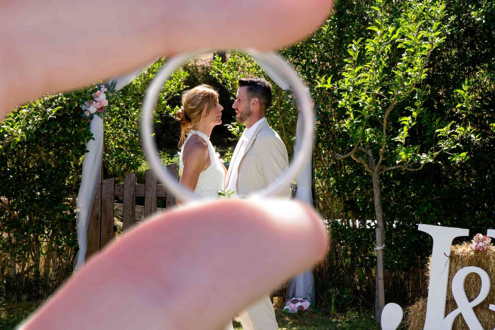 Pareja de novios posando en un jardín con árboles