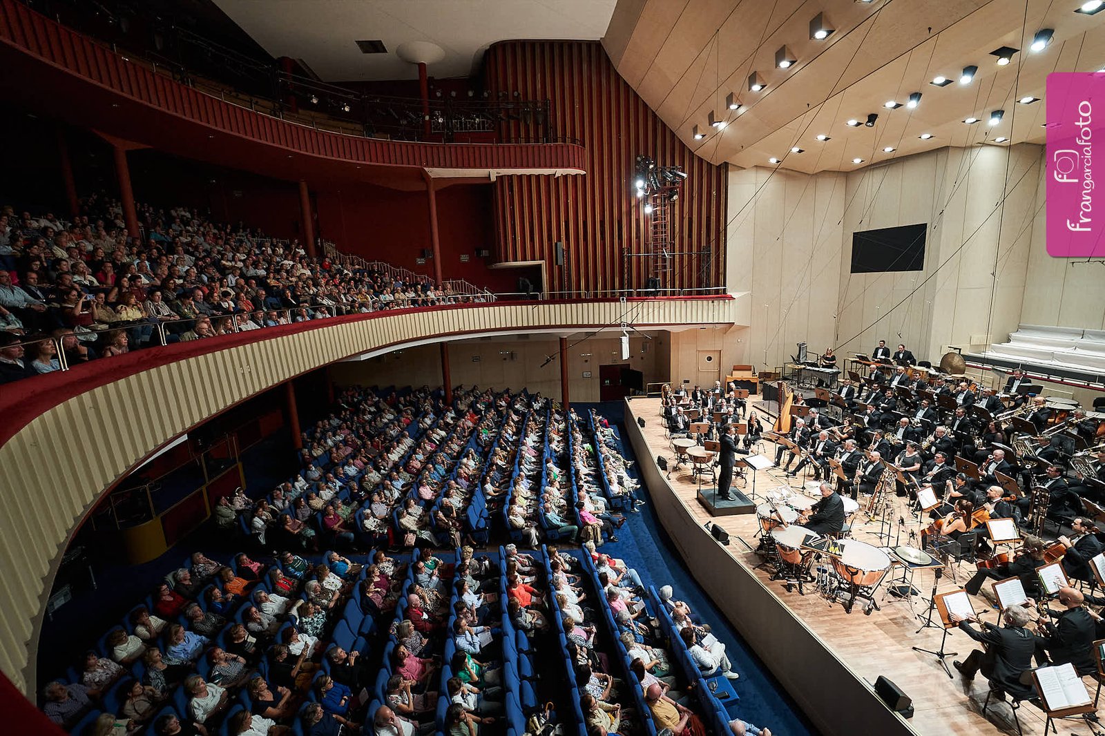 Orquesta actuando delante del público en un auditorio