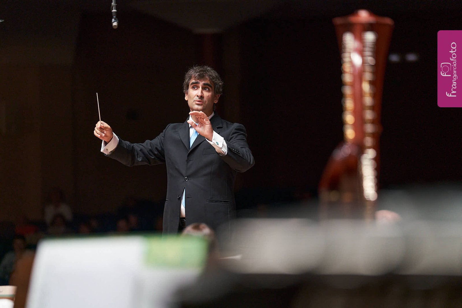 Director de Orquesta dirigiendo sus músicos en un auditorio