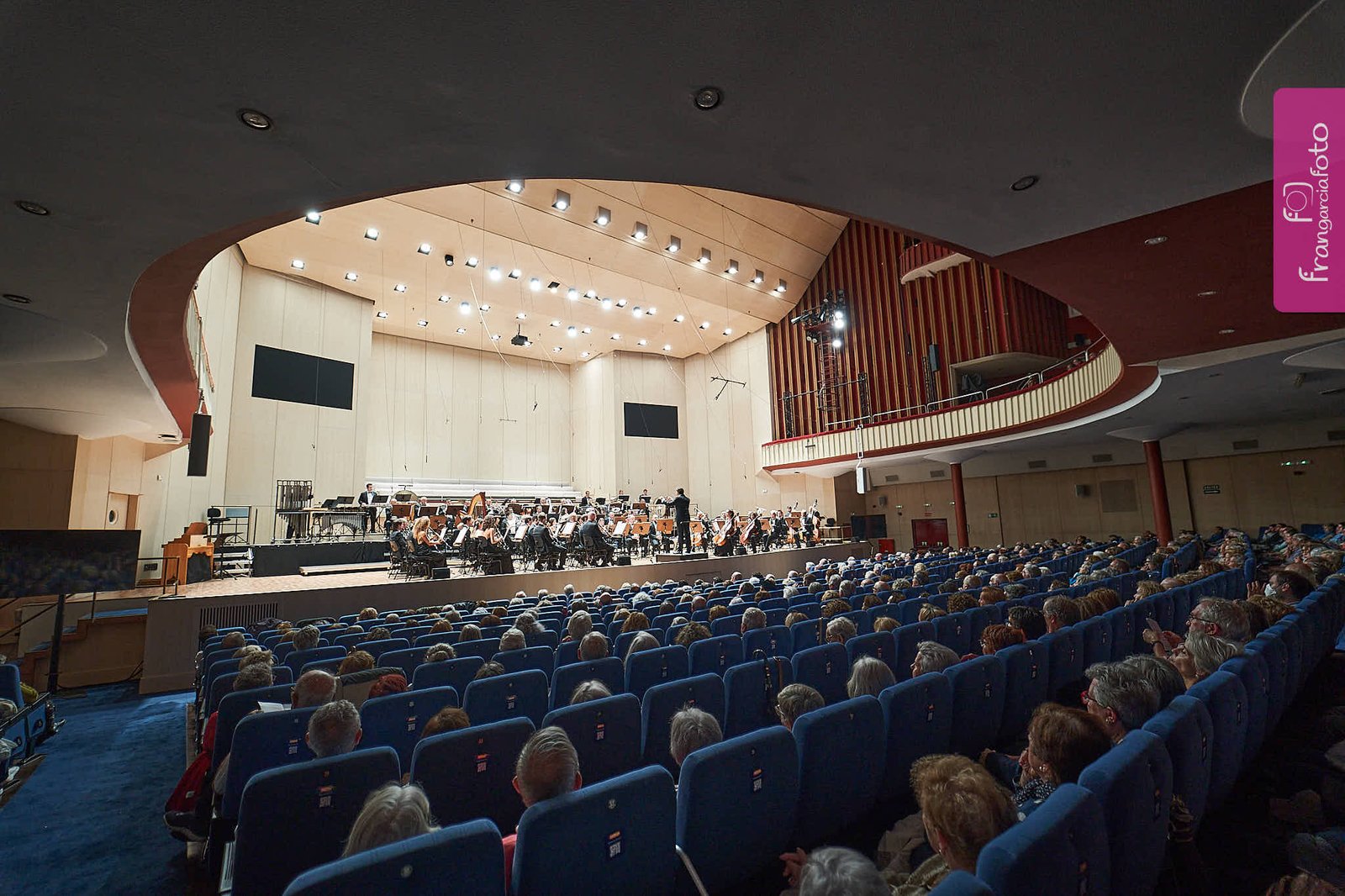 Orquesta actuando delante del público en un auditorio
