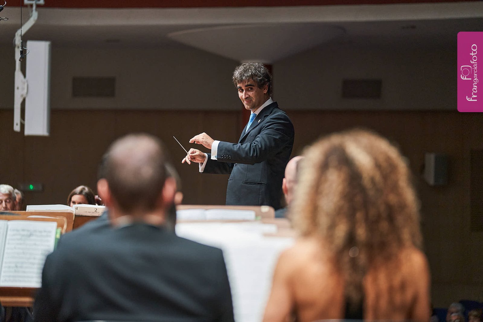 Director de Orquesta dirigiendo sus músicos en un auditorio